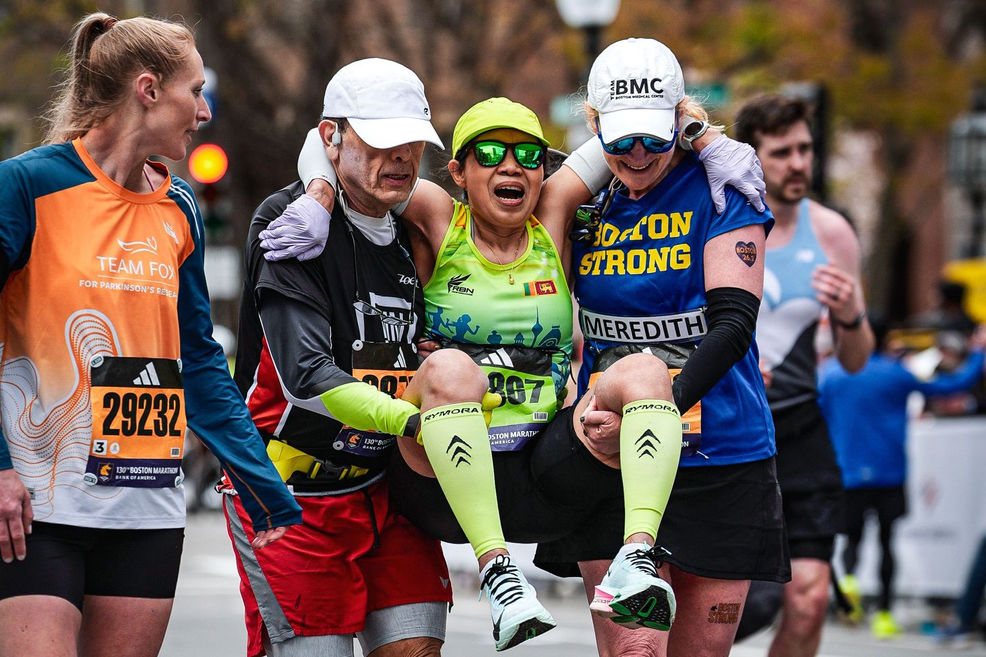 Runners were struggling to finish Boston Marathon when competitors came along and helped them across
